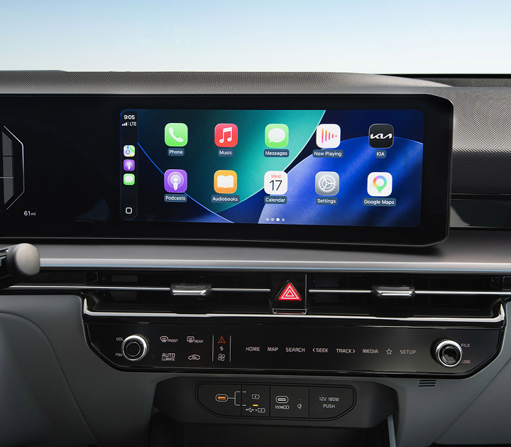 A close-up view of the Kia interior showing the digital display screen, currently featuring popular apps such as Phone, Music, Maps, Messages, Podcasts and more.